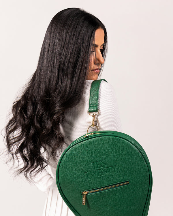 Woman wearing Ten Twenty Emirates Palms premium padel racket bag in forest green vegan leather as shoulder bag - UAE