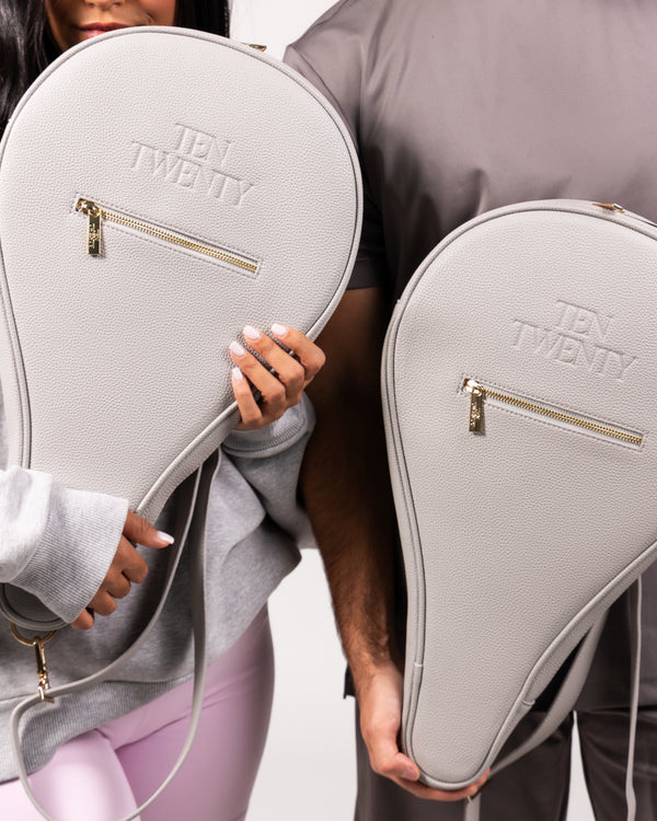 Couple holding Ten Twenty Dubai Skyline premium padel racket bags in light grey vegan leather - Ten Twenty UAE
